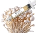 Close-up of a clear liquid culture syringe labeled ‘Myco Labs Liquid Culture Syringe,’ positioned next to a dense block covered with clusters of white enoki mushrooms